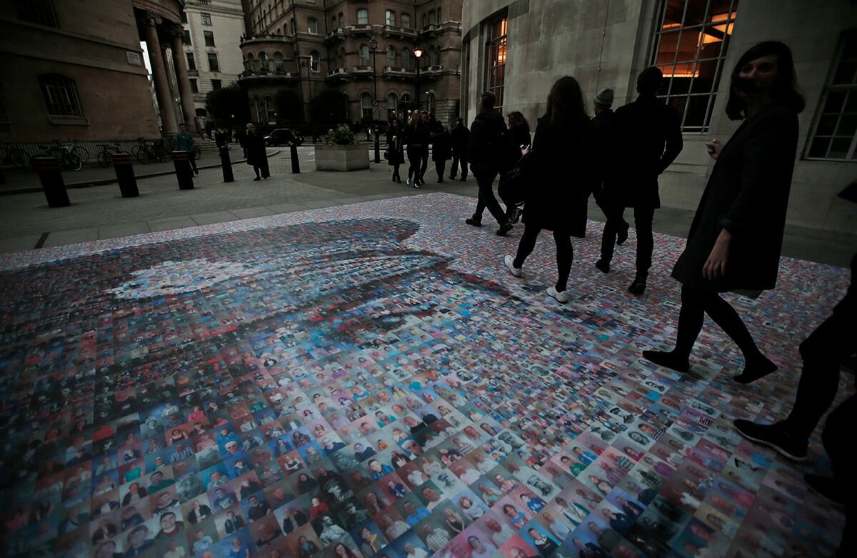 Transeúntes caminan sobre un mosaico digital de fotografías que conforman la cara de James Ernest Beanery, un soldado británico asesinado durante la Primera Guerra mundial. (AP)