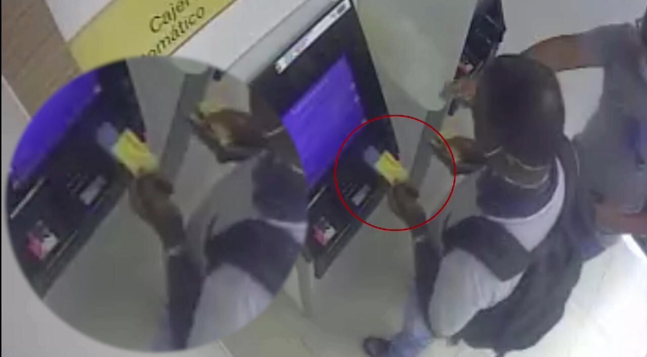 Momento en el que uno de los delincuentes le hace el cambiazo de tarjeta a una de sus víctimas tras ofrecerle ayuda con el cajero automático.
