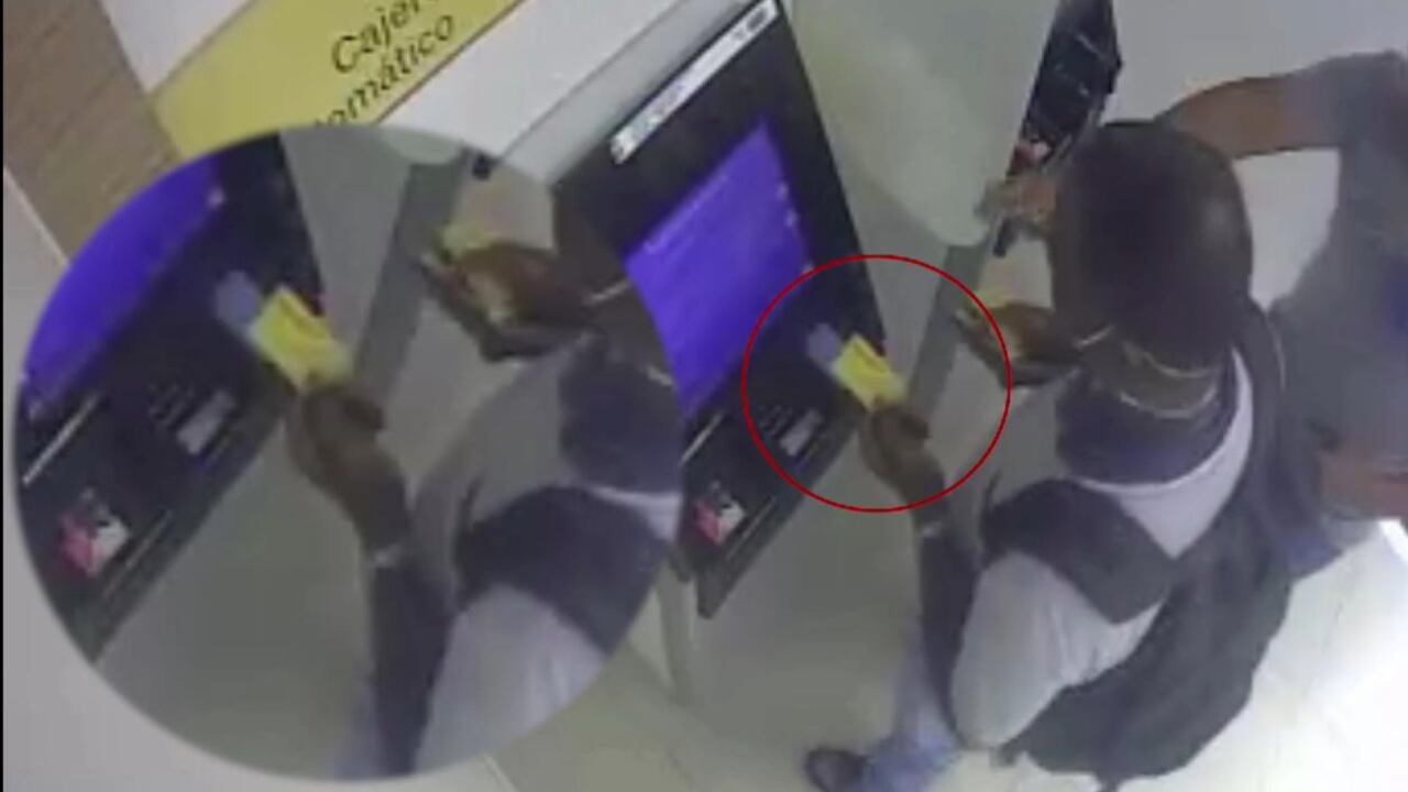 Momento en el que uno de los delincuentes le hace el cambiazo de tarjeta a una de sus víctimas tras ofrecerle ayuda con el cajero automático.