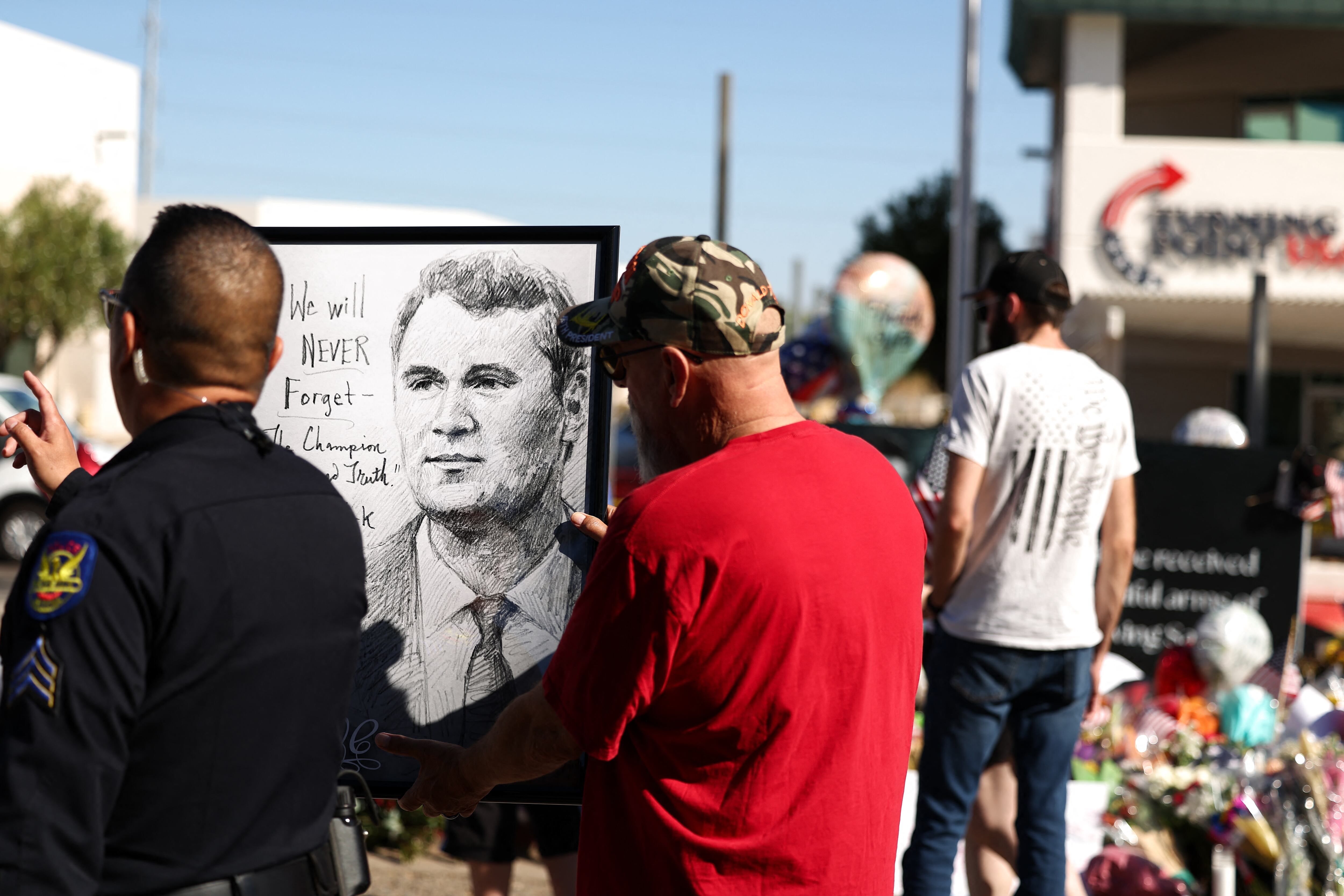 Personas se congregan en un monumento improvisado en honor al activista político y fundador de Turning Point USA, Charlie Kirk, frente a la sede de Turning Point USA en Phoenix, Arizona, el 14 de septiembre de 2025.