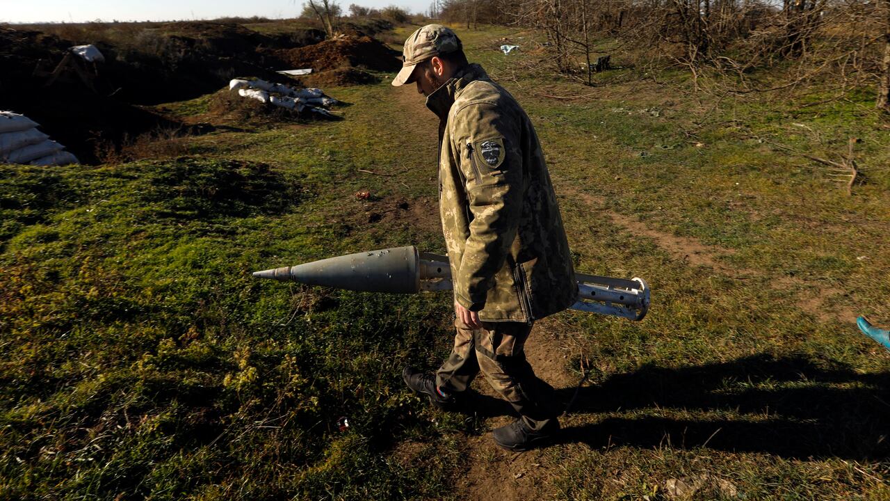 Un miembro de las Fuerzas Especiales de Ucrania, cuyas llamadas se identifican en Banderas, sostiene un casete de misiles rusos que llevaba bombas de racimo.