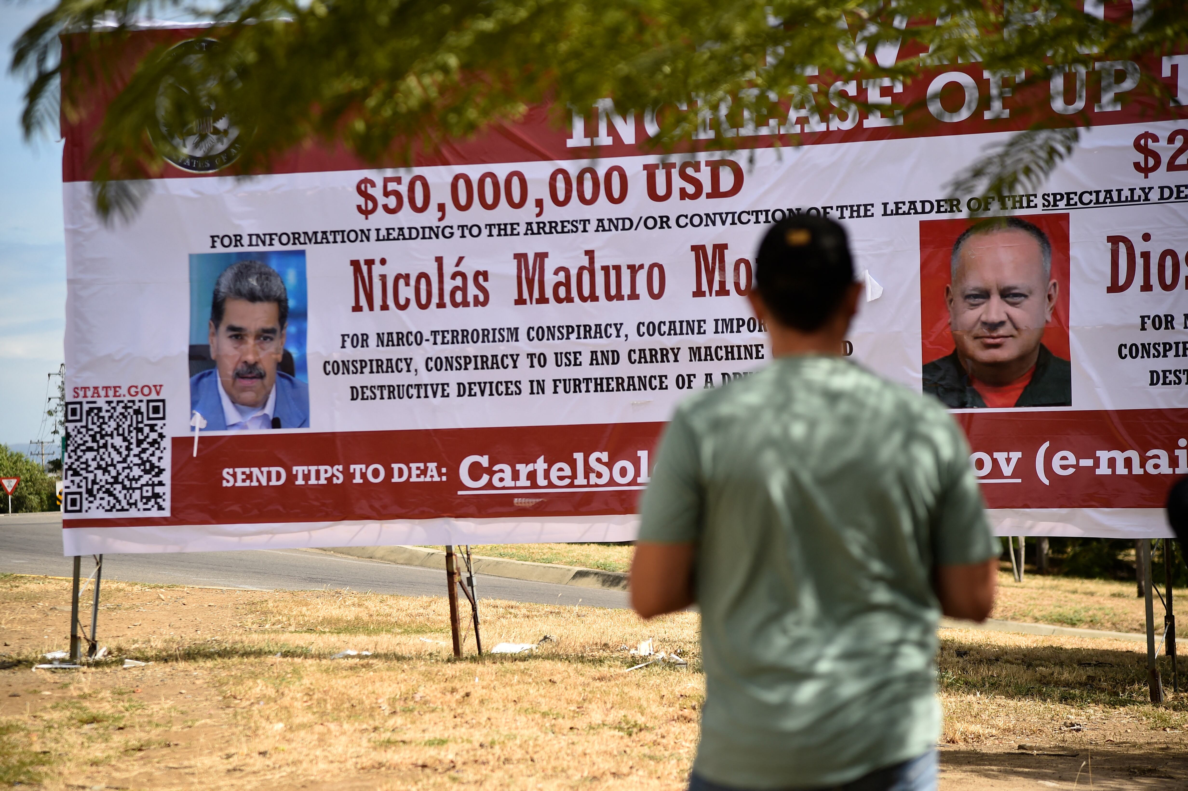 Un hombre mira un cartel que ofrece una recompensa por información que conduzca a la captura del presidente venezolano Nicolás Maduro y del ministro de Relaciones Interiores, Justicia y Paz de Venezuela, Diosdado Cabello, en Villa del Rosario, Departamento de Norte de Santander, Colombia.