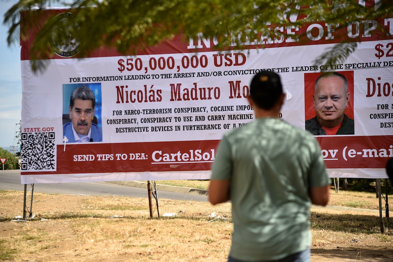 Un hombre mira un cartel que ofrece una recompensa por información que conduzca a la captura del presidente venezolano Nicolás Maduro y del ministro de Relaciones Interiores, Justicia y Paz de Venezuela, Diosdado Cabello, en Villa del Rosario, Departamento de Norte de Santander, Colombia.