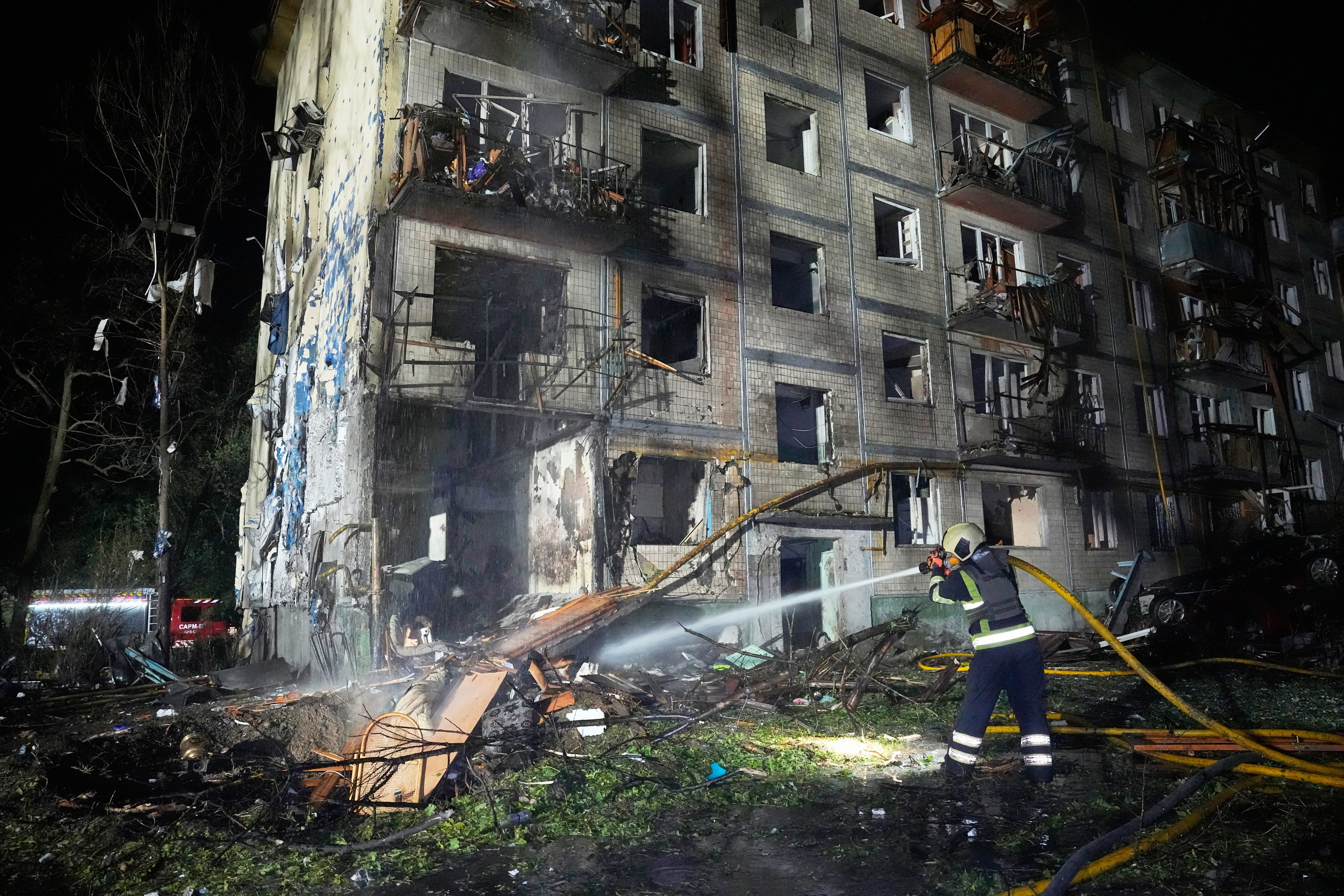 Personal de los servicios de emergencias extinguen un incendio tras un ataque ruso con misiles, en Kiev, Ucrania.