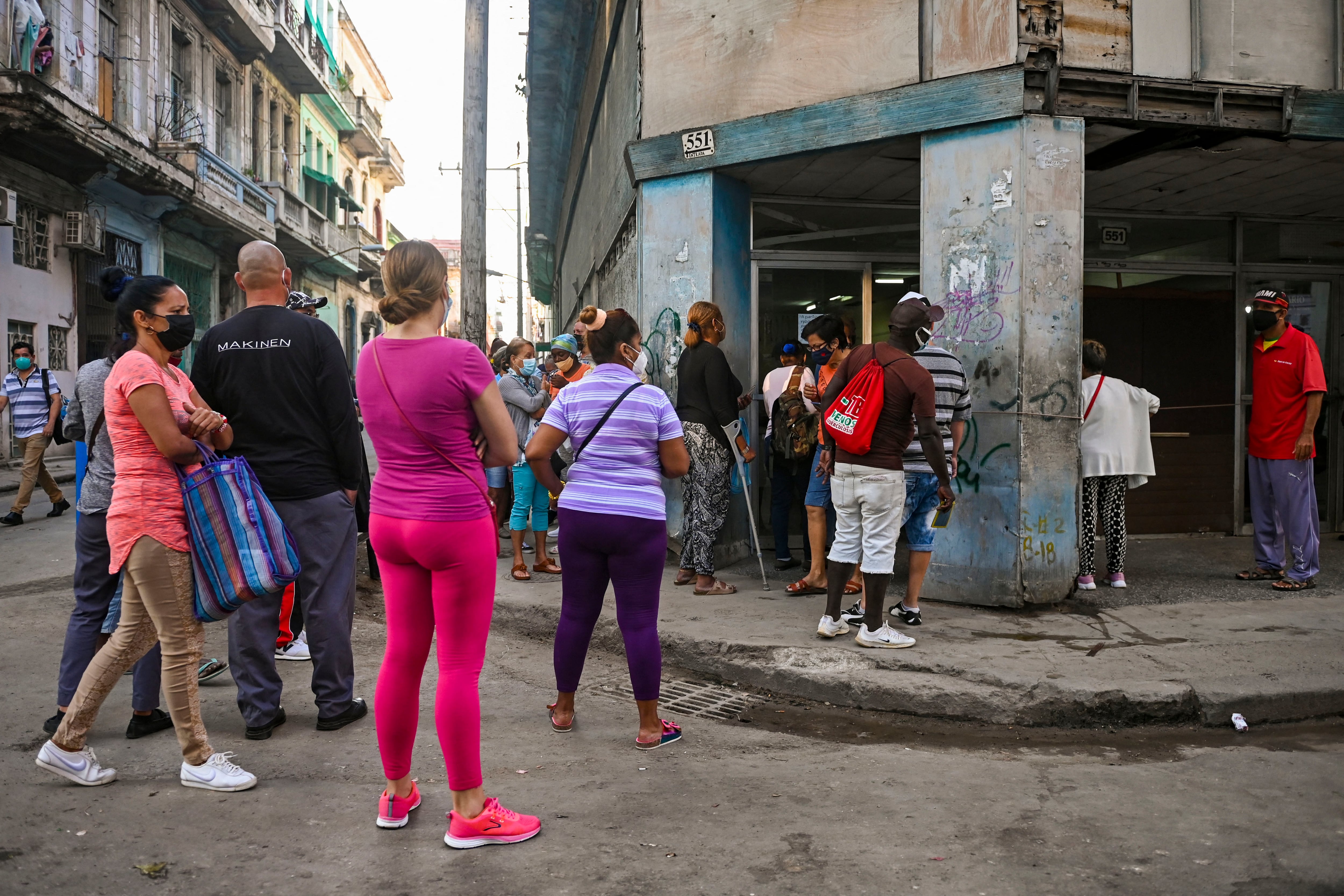 En medio de un pesado sol, cubanos se mantienen en las filas para acceder a bienes básicos. (Photo by Yamil LAGE / AFP)
