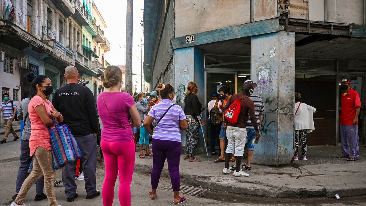 En medio de un pesado sol, cubanos se mantienen en las filas para acceder a bienes básicos. (Photo by Yamil LAGE / AFP)