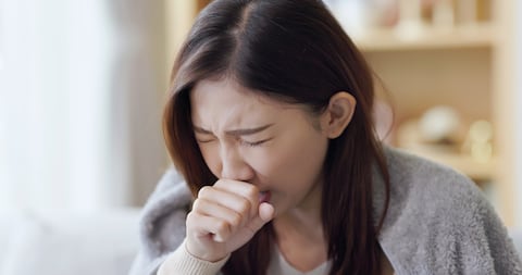 Mujer asiática tosiendo