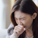 Mujer asiática tosiendo