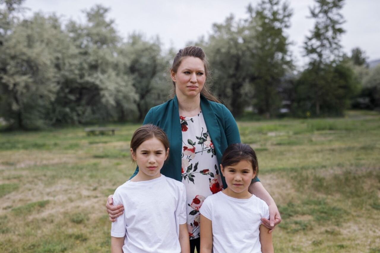 La profesora Bonnie Lepine Antoine con sus hijos Sequoia (izq.) y Maya posan en la Ecole Collines-D'Or, donde ayudó a realizar un programa conjunto con la Asociación Francófona de Kamloops para grabar a los niños hablando sobre la historia del sistema de escuelas residenciales de Canadá, en Kamloops, Canadá, el 3 de junio de 2021. Foto de Cole Burston / AFP