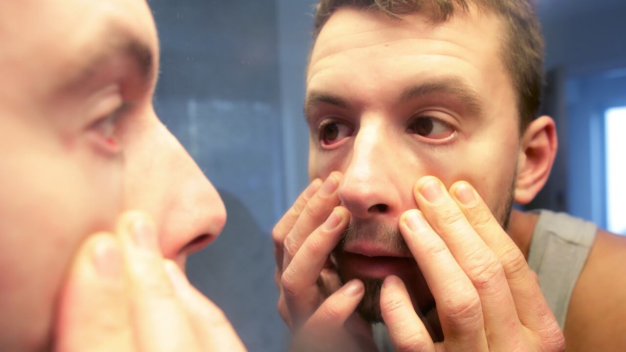 Hombre mirándose a los ojos en el espejo - Foto de referencia