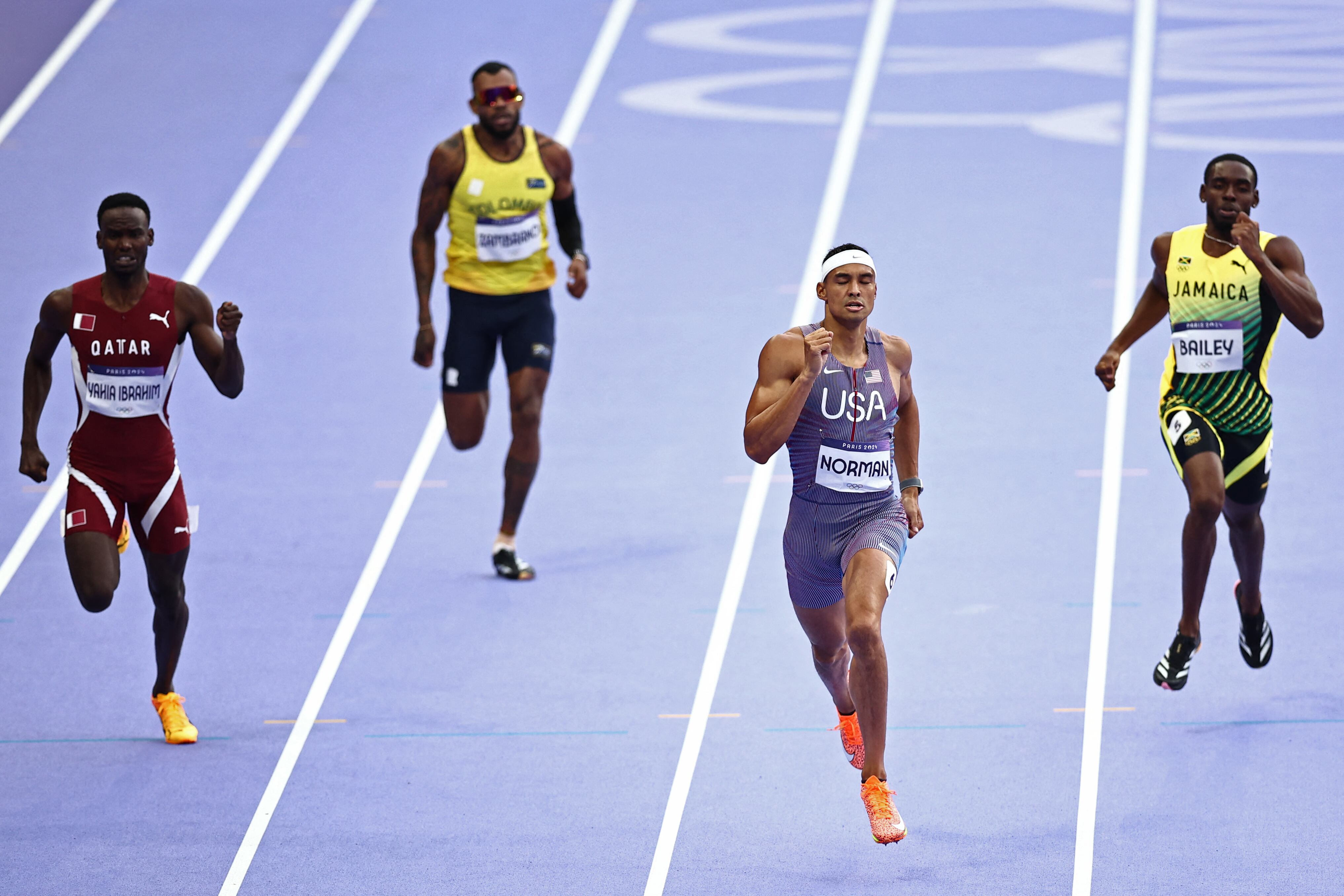 (FromL) Qatar's Ammar Ismail Yahia Ibrahim, Colombia's Anthony Jose Zambrano, US' Michael Norman and Jamaica's Sean Bailey compete in the men's 400m heat of the athletics event at the Paris 2024 Olympic Games at Stade de France in Saint-Denis, north of Paris, on August 4, 2024. (Photo by Anne-Christine POUJOULAT / AFP)