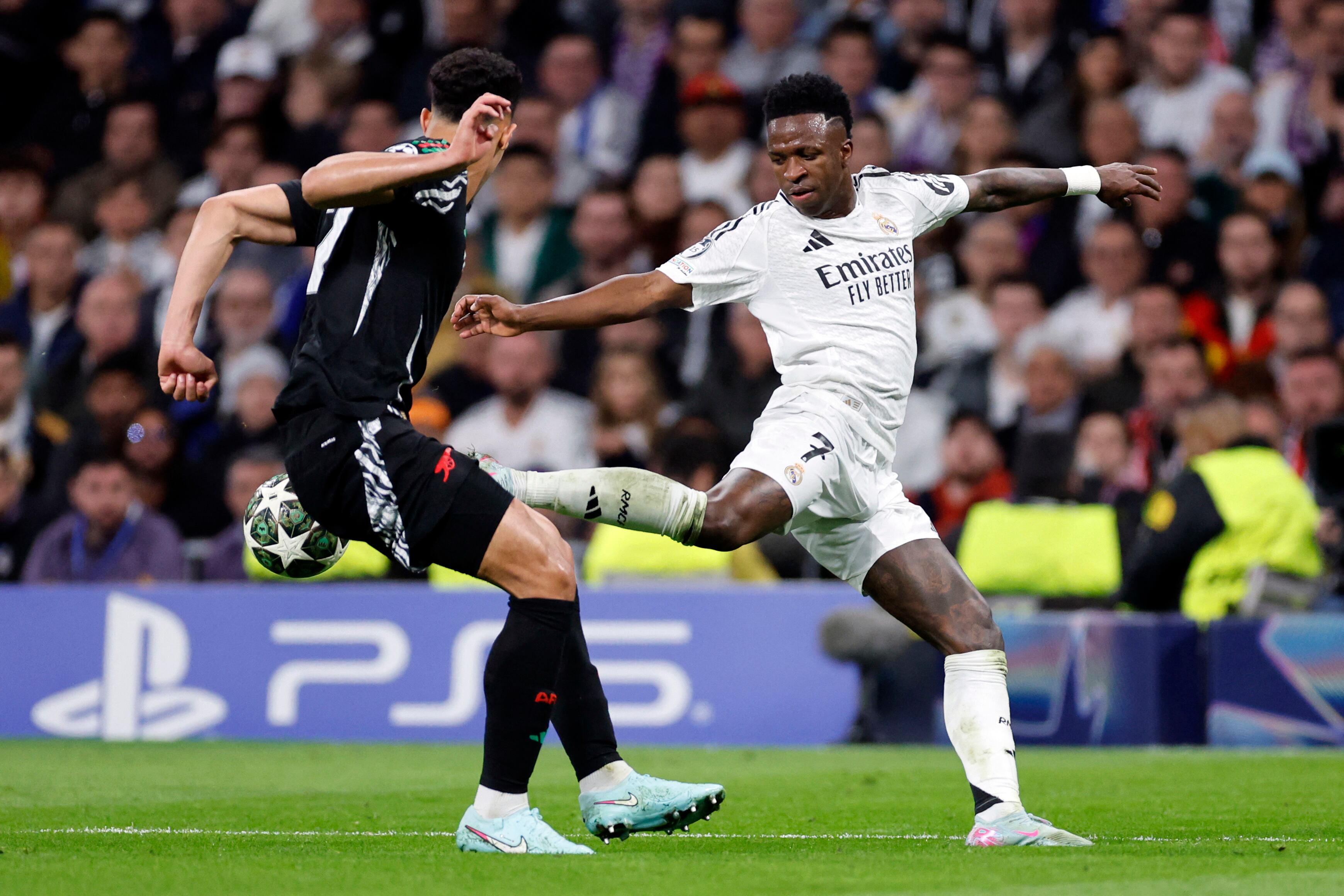 El defensa francés #02 del Arsenal, William Saliba, y el delantero brasileño #07 del Real Madrid, Vinicius Junior, compiten por el balón durante el cuarto de final de la UEFA Champions League.