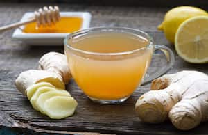 Ginger homemade tea infusion on wooden board with lemon still life