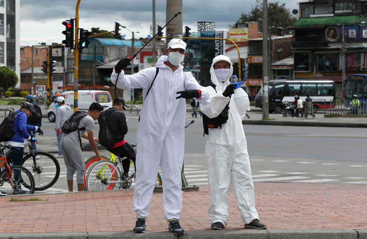 En el barrio El Poa, de Bogotá, venezolanos desinfectan y piden dinero.