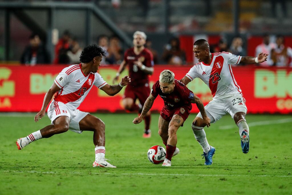 LIMA, PERU - NOVEMBER 21: Yeferson Soteldo (C) of Venezuela struggles for the ball against Renato Tapia (L) and Pedro Aquino (R) of Peru during the FIFA World Cup 2026 Qualifier match between Peru and Venezuela at Estadio Nacional de Lima on November 21, 2023 in Lima, Peru. (Photo by Daniel Apuy/Getty Images)