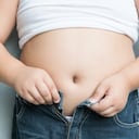 El tamaño del estómago del gordito con sobrepeso.