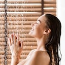 Woman Taking Shower Enjoying Water Splashing On Her, Side View