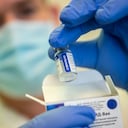 A health worker holds a vial of the Russian vaccine Sputnik V Bacs-Kiskun County Training Hospital in Kecskemet, Hungary, Friday, Feb. 19, 2021, as the vaccination with Sputnik V against the new coronavirus continues in the country. (Sandor Ujvari/MTI via AP)