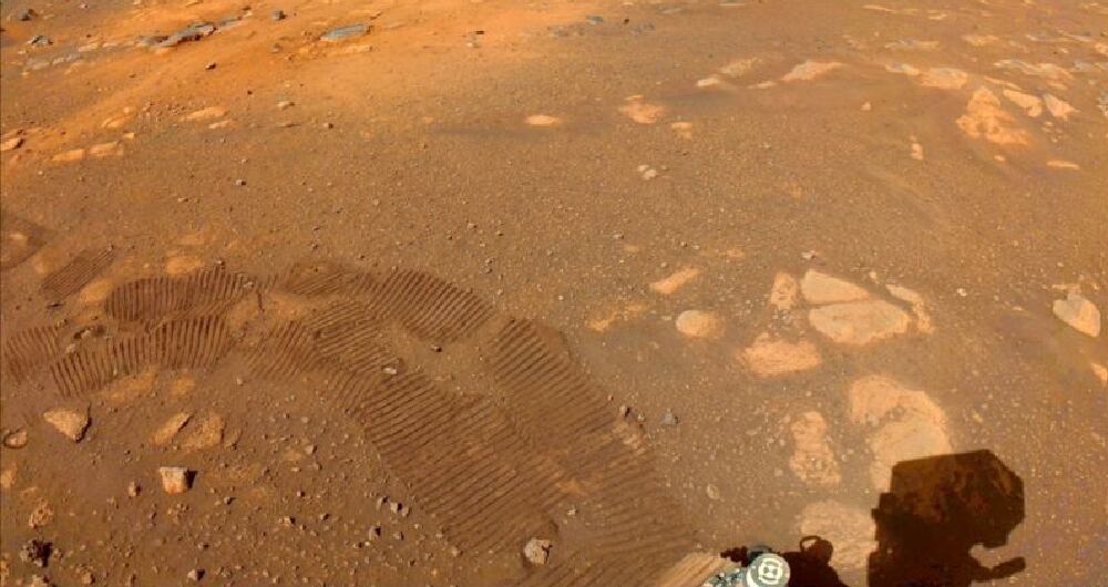 Las huellas del robot Perseverance pueden verse en esta imagen captada por una de sus cámaras el 5 de marzo. Uno de los objetivos de la misión es buscar señales de vida microbiana antigua. BBC - NASA/JPL-CALTECH