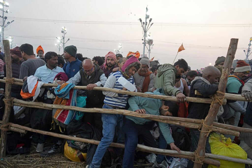 Devotos hindúes intentan cruzar una barricada para darse un baño sagrado en el Sangam, la confluencia de los ríos Ganges, Yamuna y el mítico Saraswati, en el "Mauni Amavasya" o día de luna nueva durante el festival Maha Kumbh en Prayagraj, India, el miércoles. , 29 de enero de 2025. (Foto AP/Rajesh Kumar Singh)