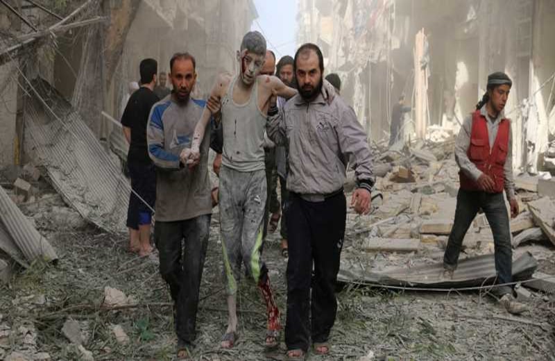 Ciudadanos sirios ayudan a un hombre herido luego de un ataque rebelde en la ciudad de Alepo.