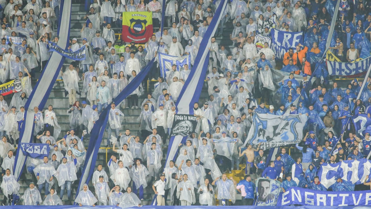 Los hinchas de Millonarios cubiertos con capas ante la fuerte lluvia que cayó en El Campín.