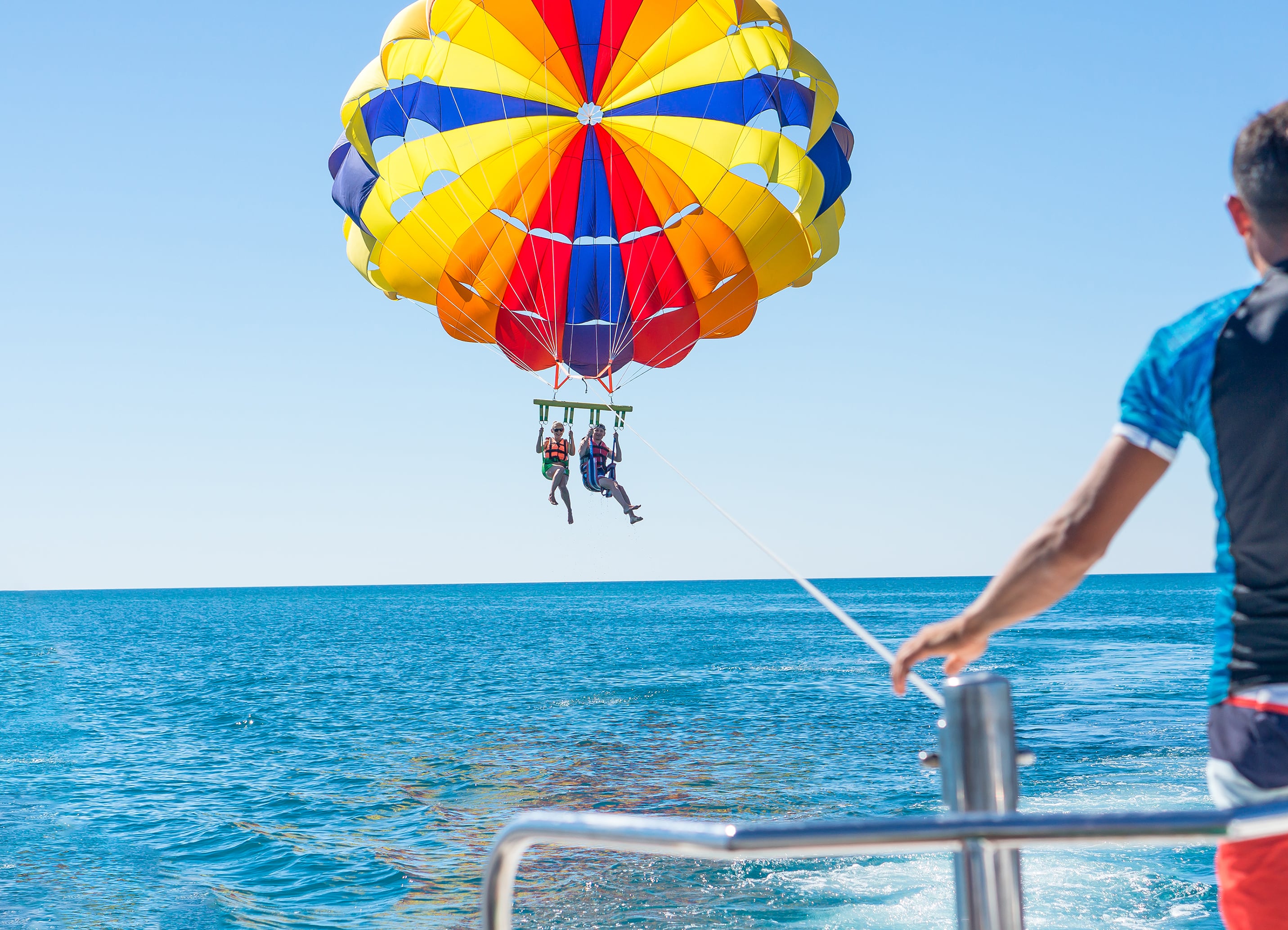 Pareja feliz haciendo parasailing en playa dominicana en verano