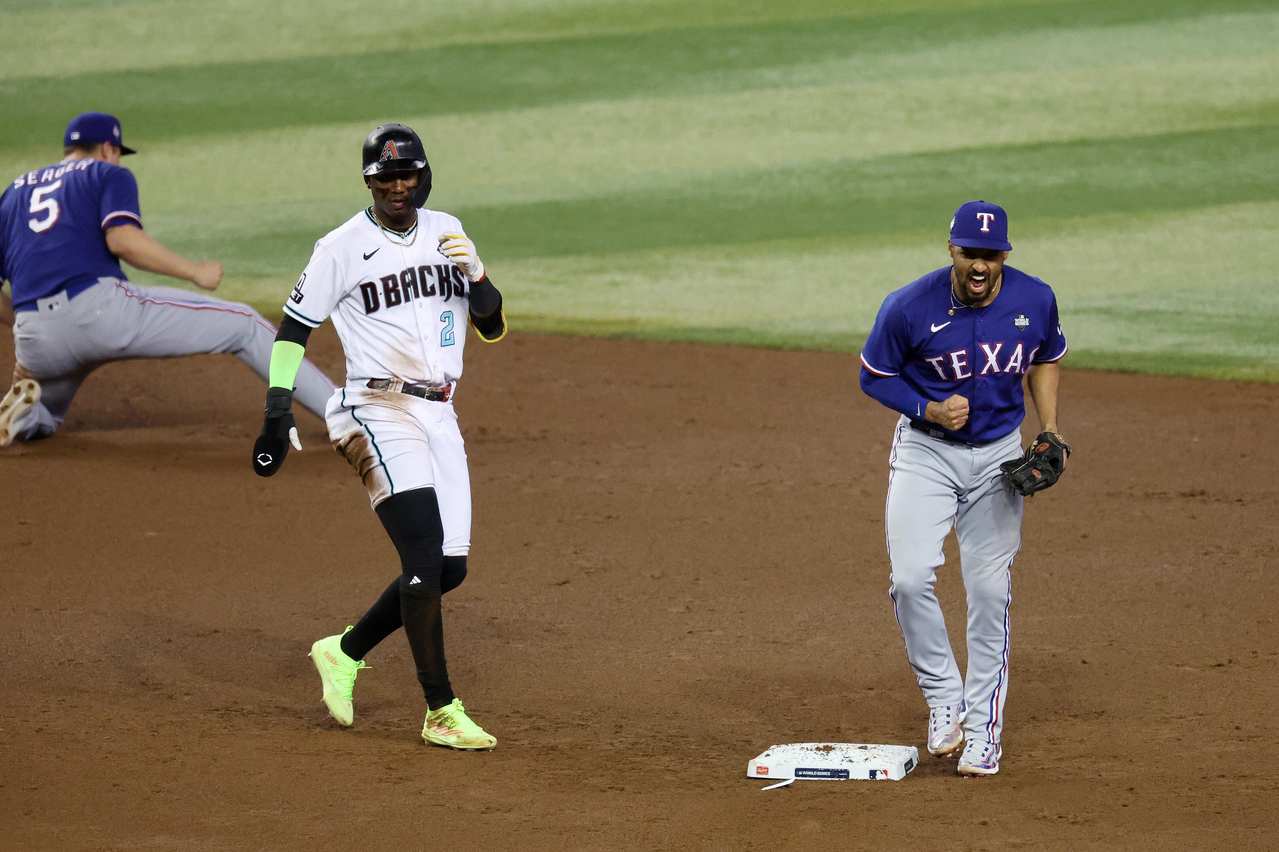 Marcus Semien # 2 de los Rangers de Texas reacciona después de girar un doble juego pasado Geraldo Perdomo # 2 de los Diamondbacks de Arizona en la octava entrada durante el Juego Tres de la Serie Mundial en el Chase Field el 30 de octubre de 2023 en Phoenix, Arizona.