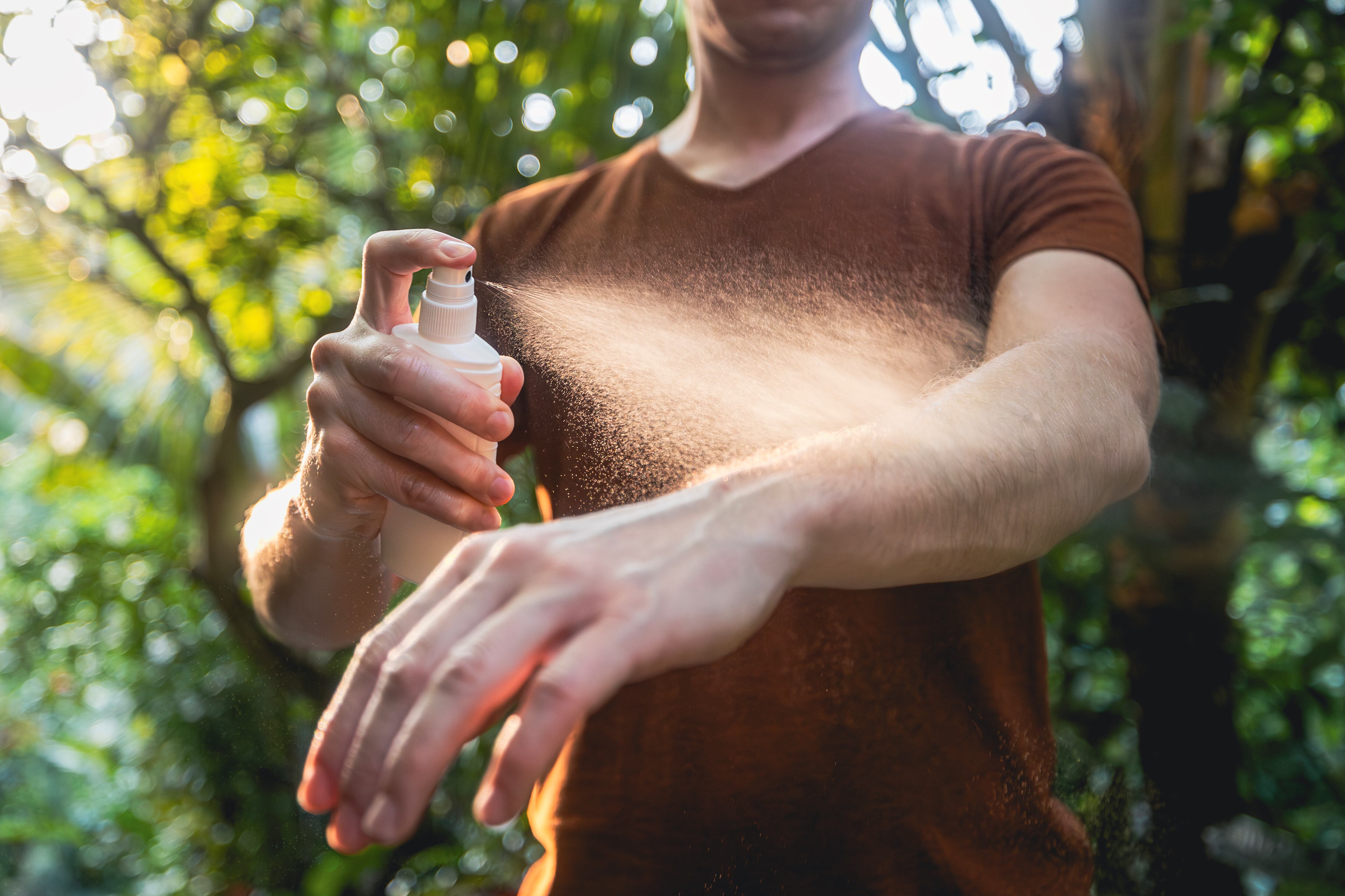 Man while applying insect repellent on his hand. Prevention against mosquito bite in tropical destination.