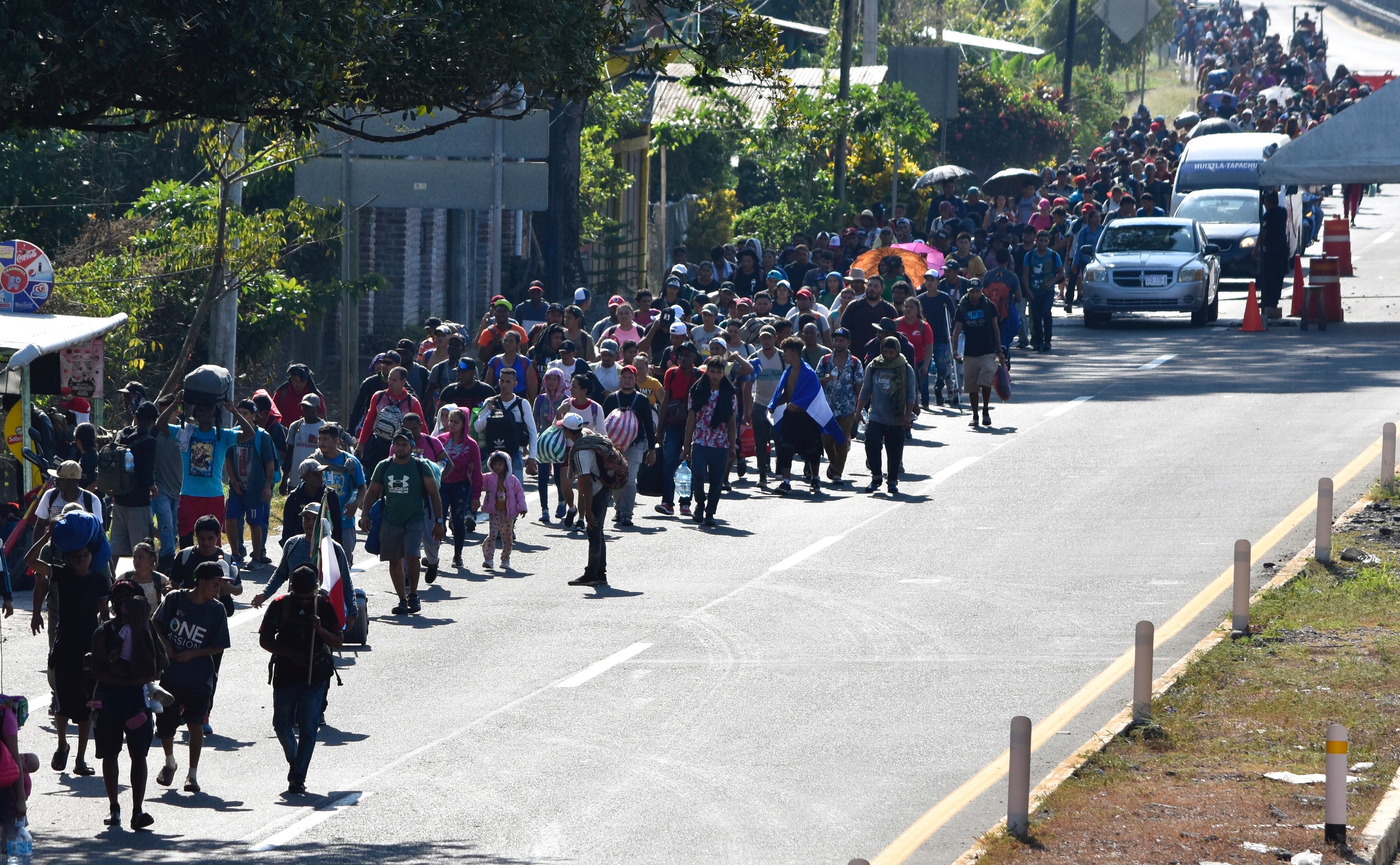 Migrants walk along a highway in Huixtla, Mexico, Monday, Dec. 25, 2023. A caravan of migrants set out north through southern Mexico just days before U.S. Secretary of State Antony Blinken arrives in Mexico City to discuss new agreements to control the surge of migrants seeking entry into the United States. (AP Photo/Edgar H. Clemente)