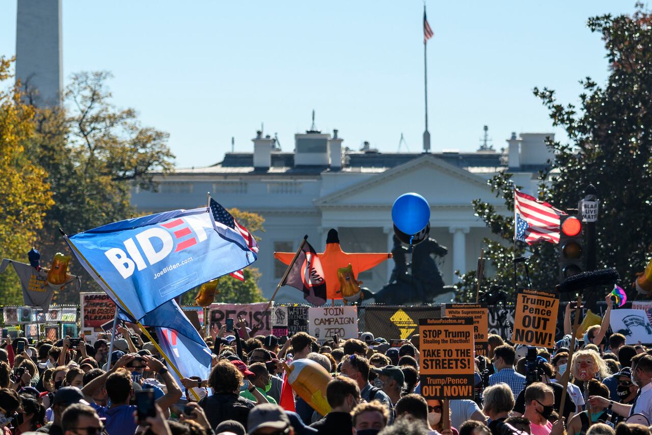 La gente celebra en la plaza Black Lives Matter frente a la Casa Blanca en Washington, DC el 7 de noviembre de 2020, después de que Joe Biden fuera declarado ganador de las elecciones presidenciales de 2020. - El demócrata Joe Biden ganó la Casa Blanca, dijeron los medios estadounidenses el 7 de noviembre, derrotando a Donald Trump y poniendo fin a una presidencia que convulsionó la política estadounidense, conmocionó al mundo y dejó a Estados Unidos más dividido que en cualquier otro momento en décadas. (Foto de Eric BARADAT / AFP)