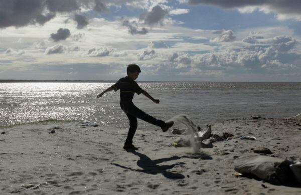 Un niño bangladesí  juega con arena en la ribera del río Padma en las afueras de Daca, capital de Bangladesh (AP) 