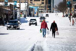 AUSTIN, TX - FEBRUARY 15: People carry groceries from a local gas station on February 15, 2021 in Austin, Texas. Winter storm Uri has brought historic cold weather to Texas, causing traffic delays and power outages, and storms have swept across 26 states with a mix of freezing temperatures and precipitation. Montinique Monroe/Getty Images/AFP (Photo by Montinique Monroe / GETTY IMAGES NORTH AMERICA / AFP)