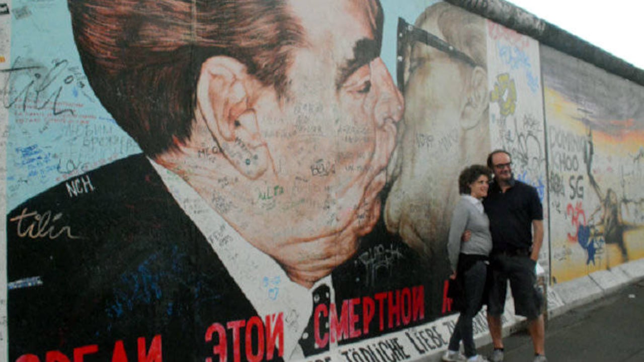 Dos turistas posan frente al 'Beso de la muerte' del artista ruso Dimitri Vrubel. Foto: Marco Bonilla