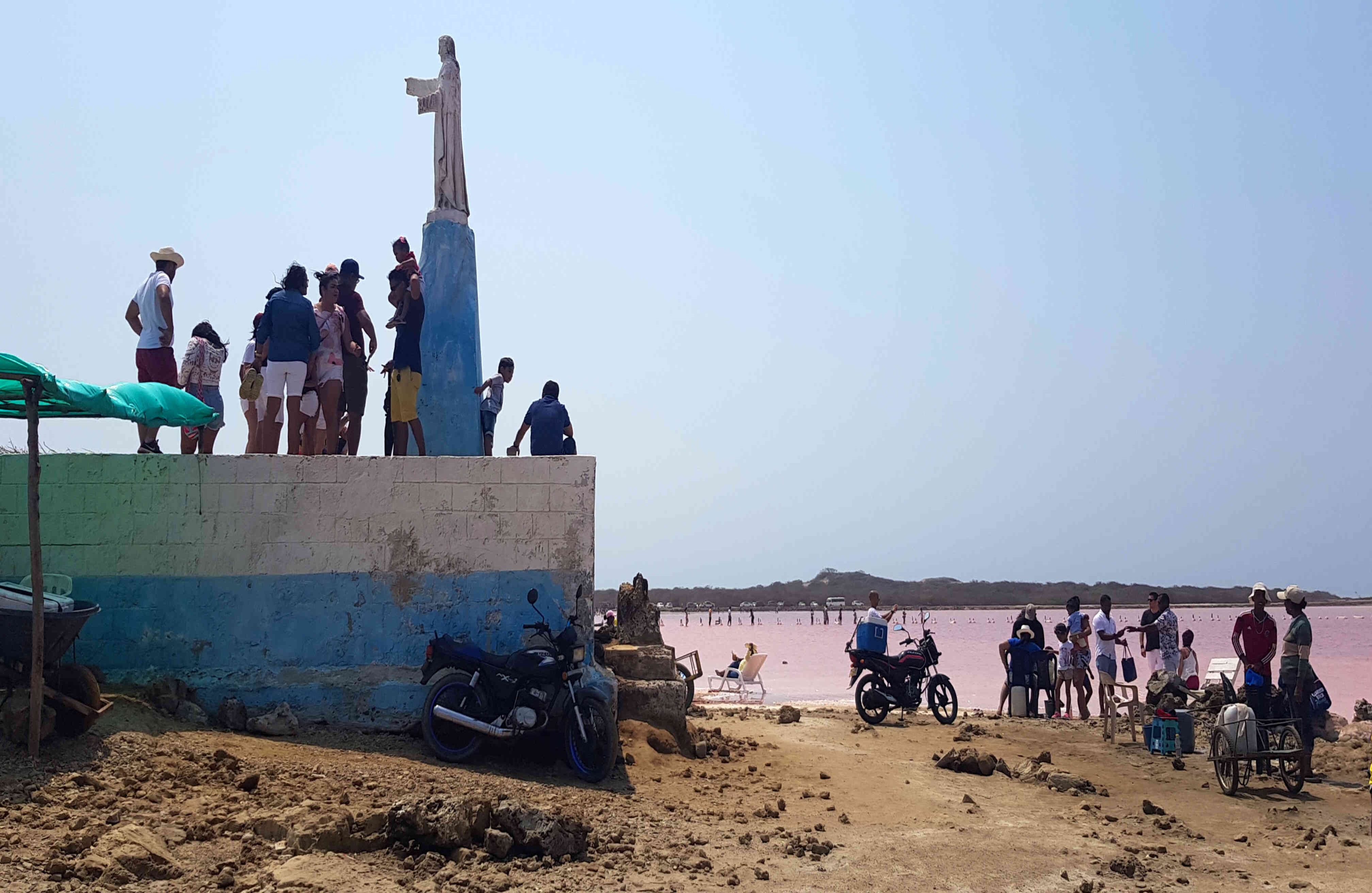 Una imagen religiosa domina el sector de las charcas y los turistas no dudan en posar con ella, teniendo como telón de fondo las aguas del mar rosado.