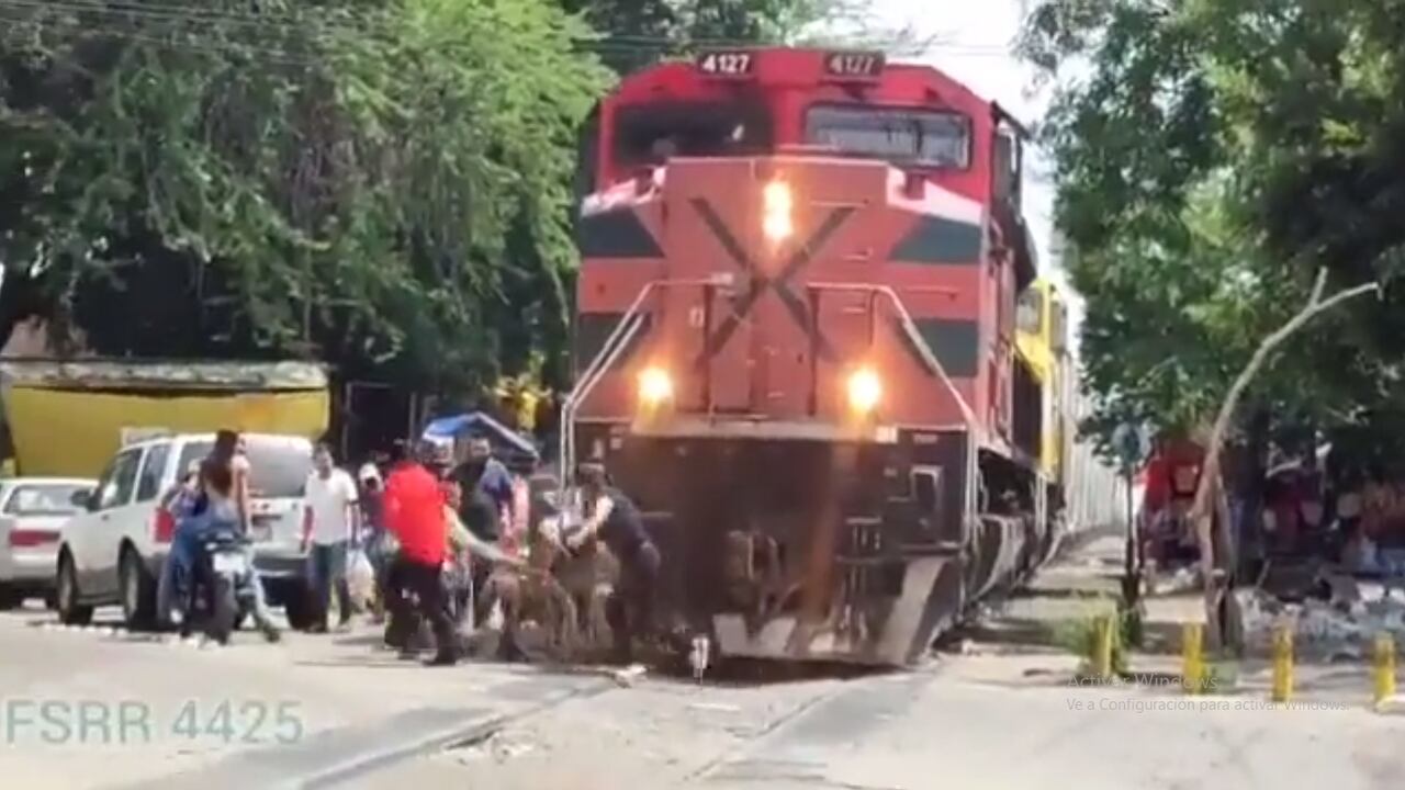 Entre más se acerca el tren, más crece el desespero entre las personas que buscan ayudar, sin éxito, al hombre.