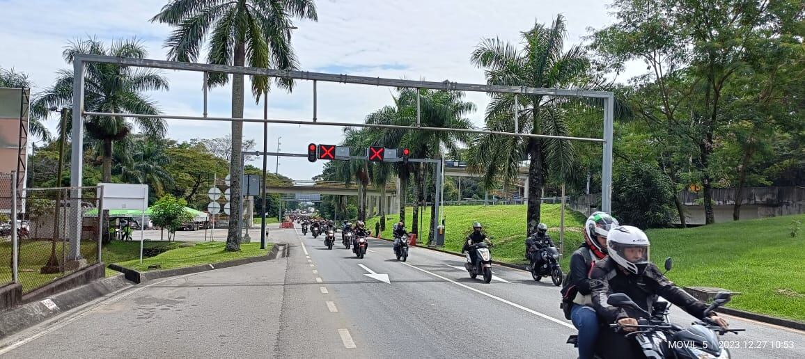 Varias motocicletas transitan por el concurrido corredor vial.