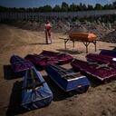 Un sacerdote bendice ataúdes con cuerpos civiles no identificados, que murieron en el territorio de la comunidad de Bucha durante el período de ocupación rusa en febrero-marzo de 2022, en un funeral en Bucha, cerca de Kyiv, Ucrania, el viernes 2 de septiembre de 2022. Foto AP/Emilio Morenatti