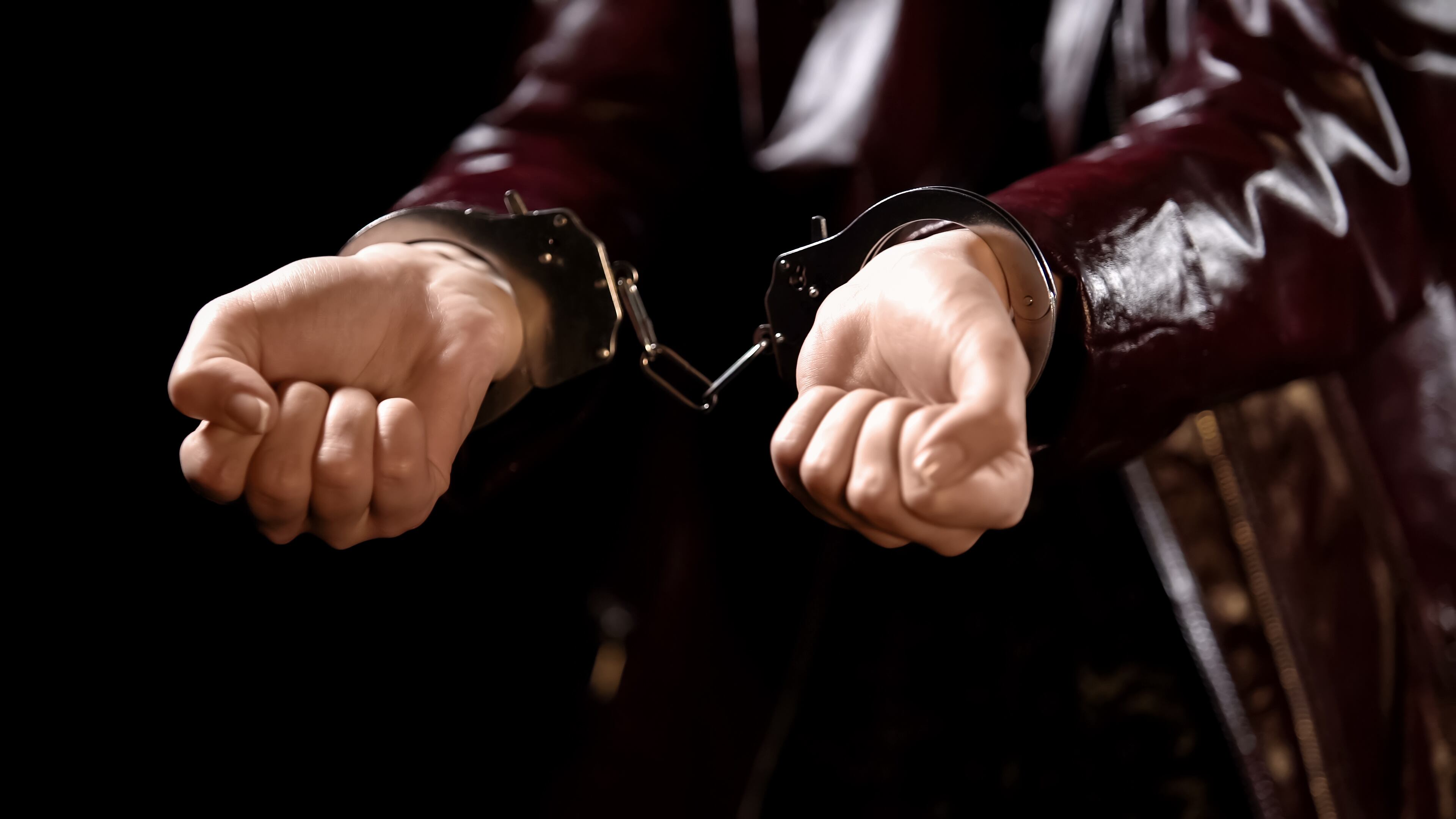 Police officer arrests young woman for prostitution, hands handcuffed close up