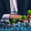 Empresario sosteniendo una moneda con un árbol que crece en una pila de monedas de dinero y un gráfico de crecimiento digital. Crecimiento empresarial verde. Financiar el desarrollo sostenible.