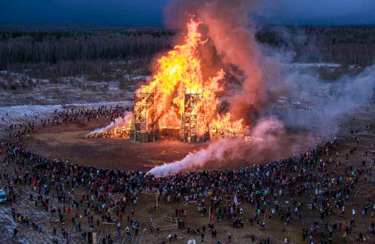 Una multitud de personas se reúne alrededor de una escultura de un puente ardiendo en la Maslenitsa (Shrovetide), festival en el parque de arte Nikola-Lenivets, en el pueblo de Nikola-Lenivets, a unos 200 kilómetros (125 millas) al suroeste de Moscú, Rusia, el 29 de febrero de 2020. Maslenitsa es una fiesta tradicional rusa que marca el final del invierno. Foto: Dmitry Serebryakov/ AP. 