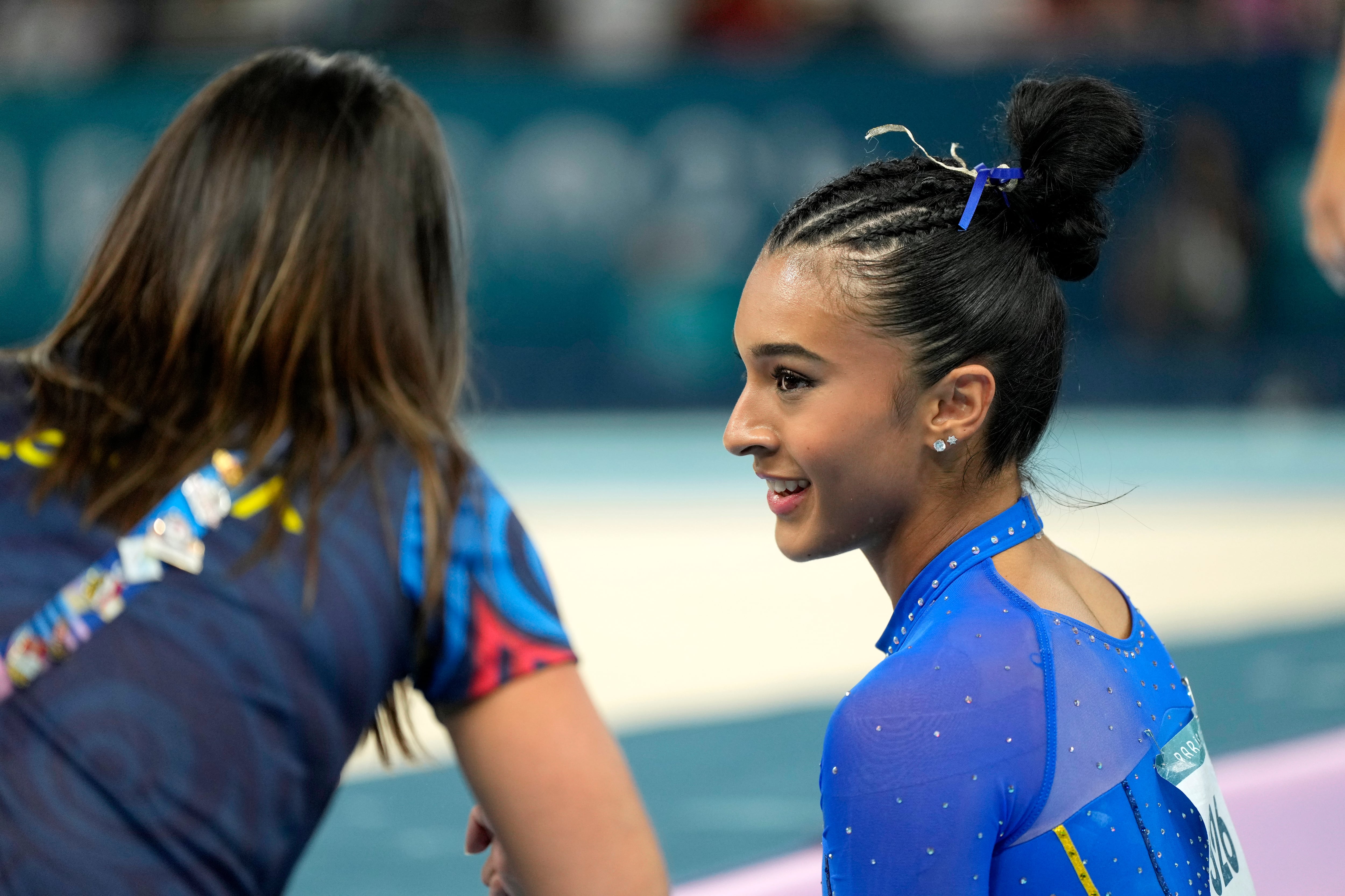 Luisa Blanco, of Colombia, talks with a coach after competing on the floor exercise during a women's artistic gymnastics qualification round at Bercy Arena at the 2024 Summer Olympics, Sunday, July 28, 2024, in Paris, France. (AP Photo/Charlie Riedel)