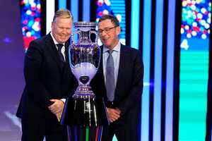 Los entrenadores de Holanda Ronald Koeman, izquierda, y Austria Ralf Rangnick, derecha, posan junto al trofeo después del sorteo de la final del torneo de fútbol UEFA Euro 2024 en Hamburgo, Alemania, el sábado 2 de diciembre de 2023. (Foto AP /Martín Meissner)