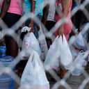 People gather outside the National Penitentiary for their turn to deliver food to their jailed relatives in downtown Port-au-Prince, Haiti, Thursday, June 1, 2023. In December 2022, the University of Florida published a study that found that men in Haiti’s prisons were on a starvation-level diet, consuming fewer than 500 calories a day. (AP Photo/Odelyn Joseph)