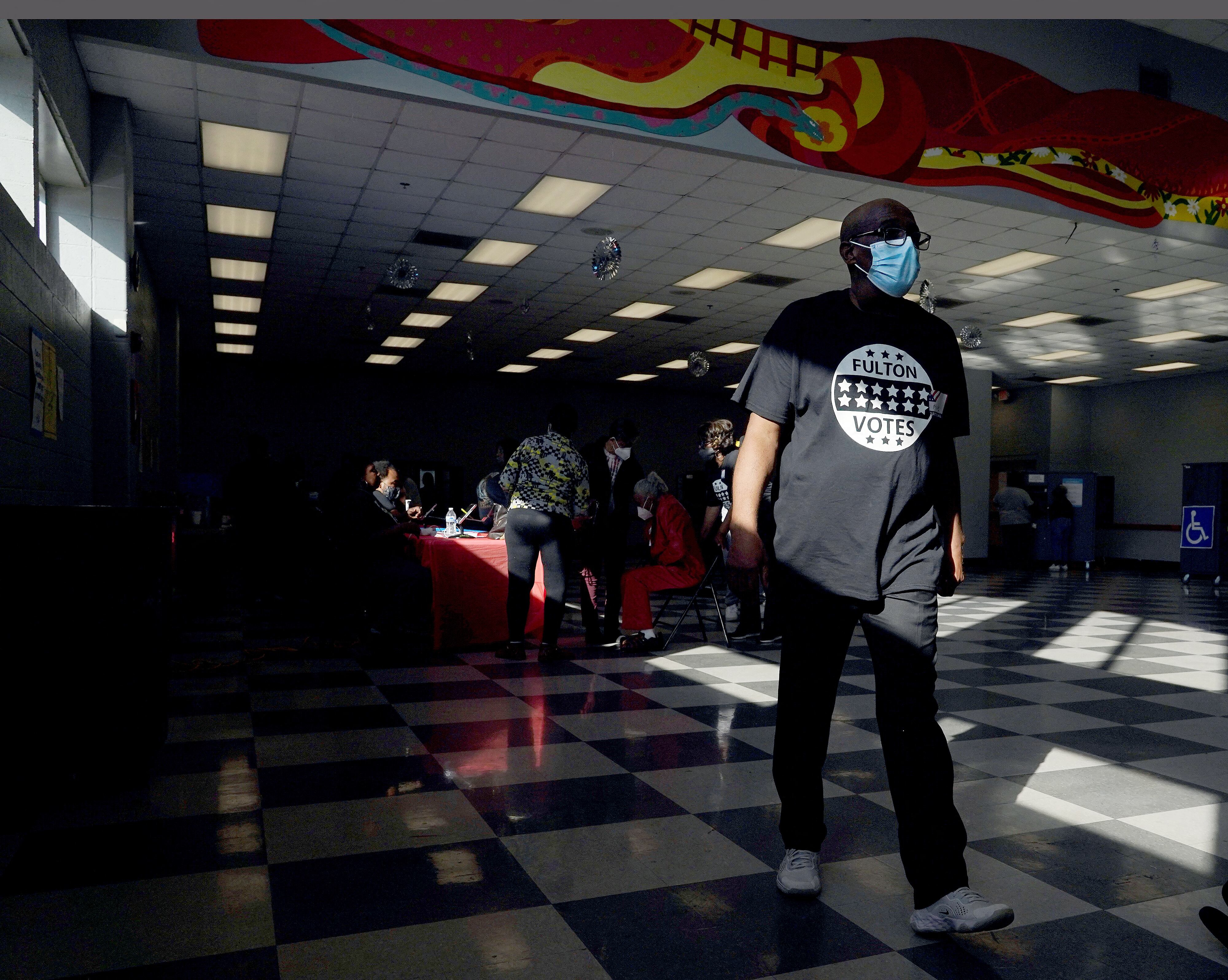 El trabajador electoral Michael Burks camina por el centro de votación en C.T. Martin Natatorium and Recreation Center en Atlanta, Georgia, el 8 de noviembre de 2022. (Foto de TAMI CHAPPELL / AFP)