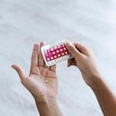 Close-up of young woman's hand holding birth control pills