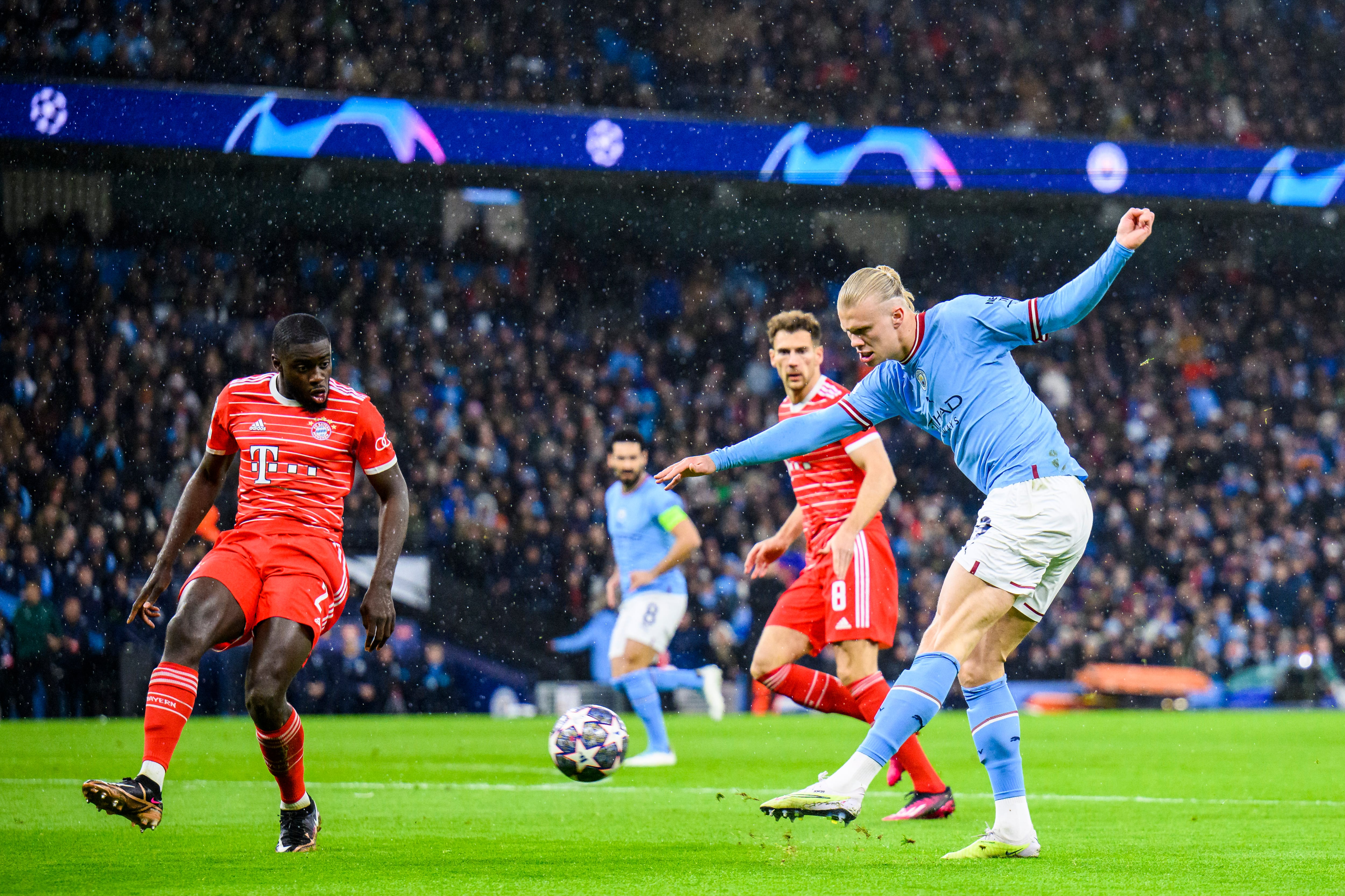 Haaland rematando al arco con Upamecano defendiendo