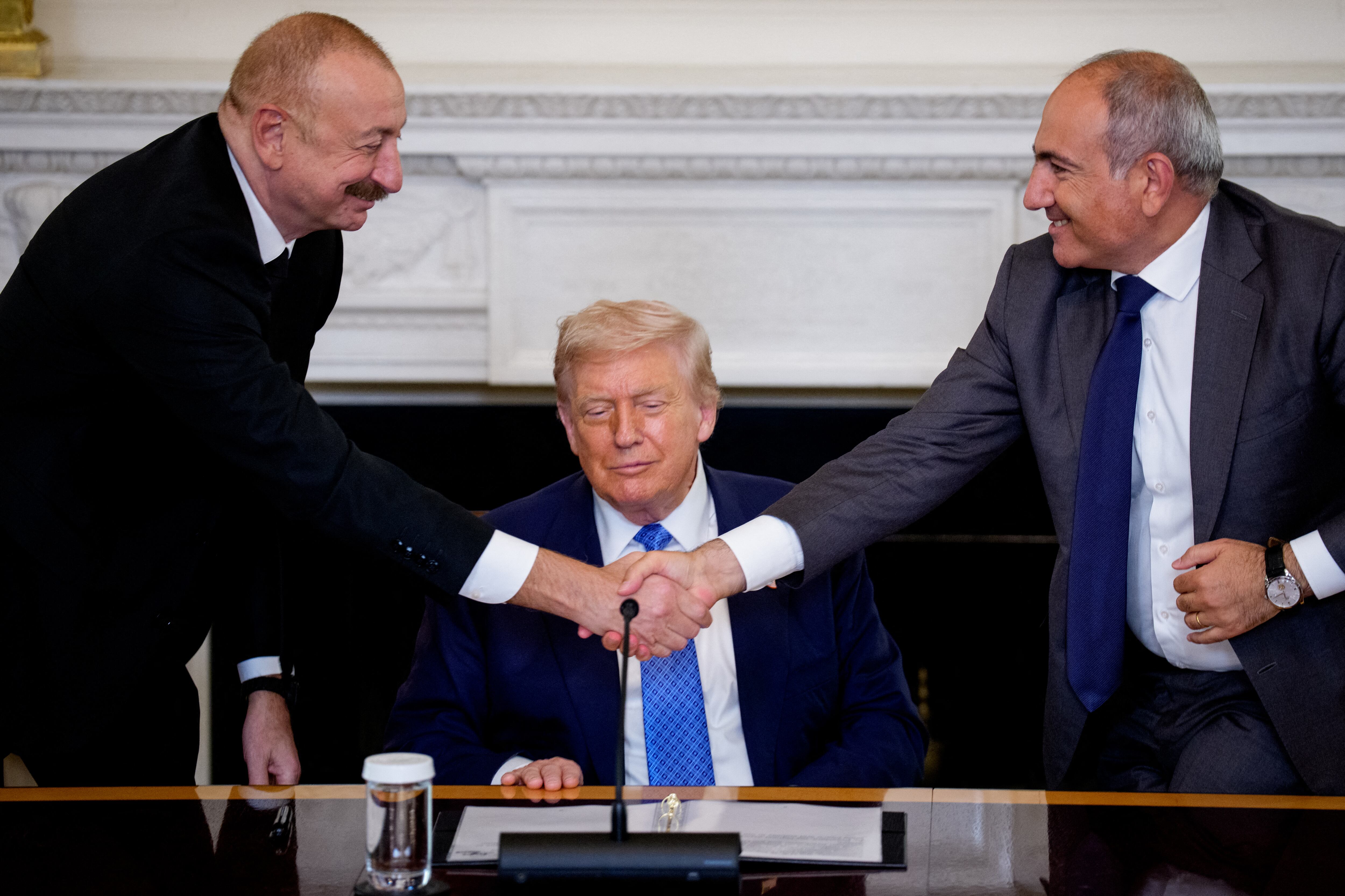 El presidente de Estados Unidos, Donald Trump (centro), observa cómo el presidente azerbaiyano, Ilham Aliyev (izq.), y el primer ministro armenio, Nikol Pashinyan (der.), se estrechan la mano