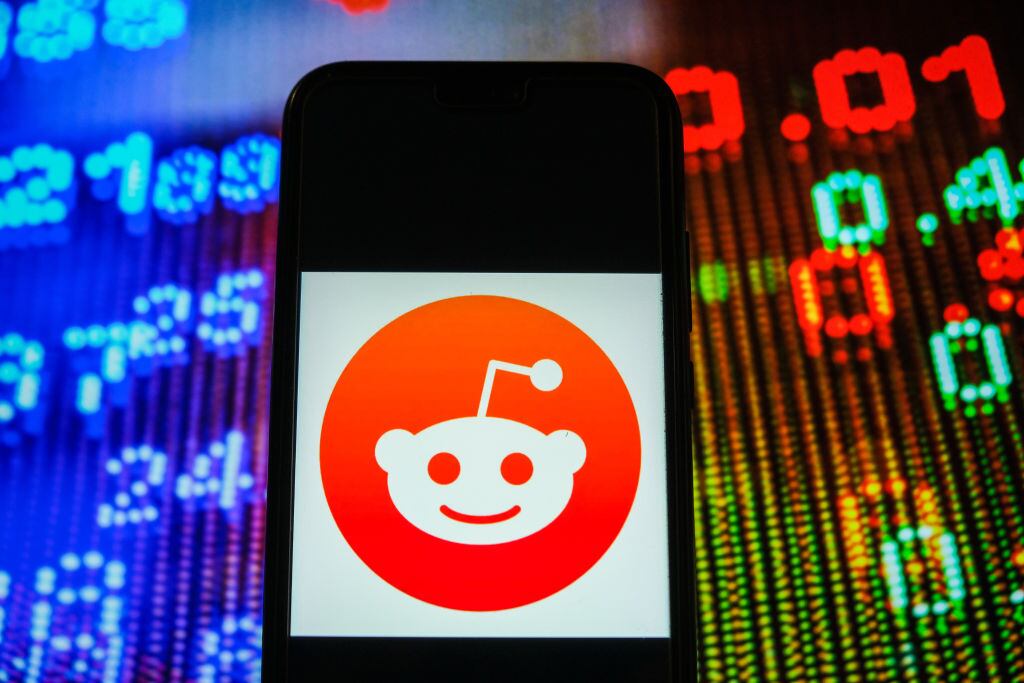 POLAND - 2021/01/05: In this photo illustration, a Reddit logo seen displayed on a smartphone with stock market prices in the background. (Photo Illustration by Omar Marques/SOPA Images/SOPA Images/LightRocket via Getty Images)