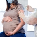 Vacunación para embarazadas. Mujer embarazada en mascarilla vacunarse en la clínica. Doctor dando paciente de inyección de vacuna contra el virus Corona. Protección contra la influenza Covid-19. Enfoque selectivo. Jeringa de cerca. Banner 3: 1